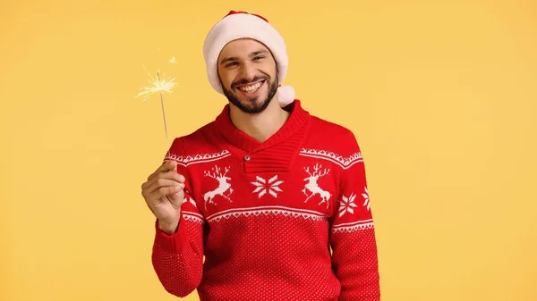 Homem alegre segurando brilhante sparkler isolado no amarelo — Fotografia de Stock