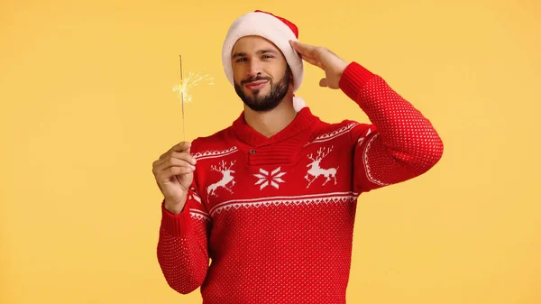 Bearded man holding shiny sparkler isolated on yellow — Stockfoto