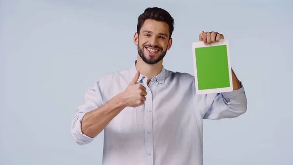 Felice uomo mostrando pollice in alto e tenendo tablet digitale con schermo verde isolato su blu — Foto stock