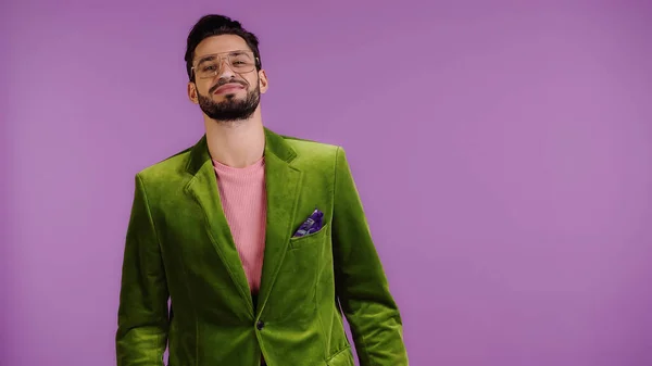 Pleased man in green jacket isolated on purple — Foto stock