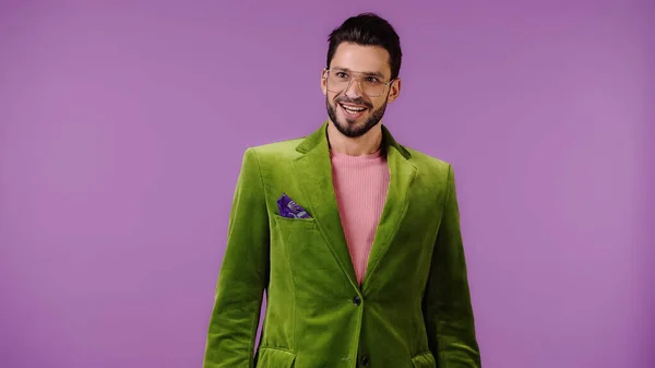 Jovem feliz em casaco verde isolado em roxo — Fotografia de Stock