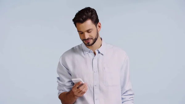Hombre feliz utilizando el teléfono móvil aislado en azul — Stock Photo