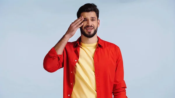 Dissatisfied and bearded man in red shirt isolated on blue — Foto stock