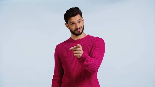 Uomo in maglione rosa punta con dito isolato su blu — Foto stock