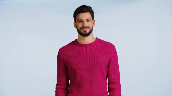 Fröhlicher und bärtiger Mann in rosa Pullover isoliert auf blauem Grund — Stockfoto