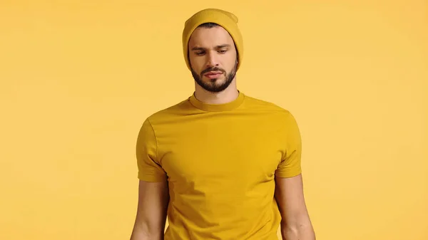 Molesto joven en gorro sombrero aislado en amarillo — Stock Photo