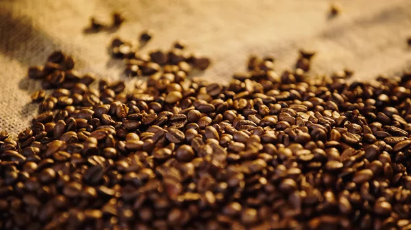Primer plano de granos de café tostados sobre lienzo - foto de stock