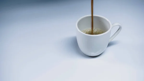 Expresso chaud versant dans la tasse sur blanc — Photo de stock