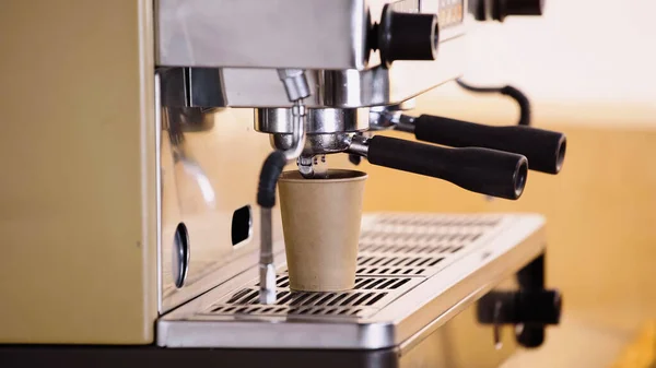 Cafetière professionnelle versant boisson dans une tasse en papier dans un café moderne — Photo de stock