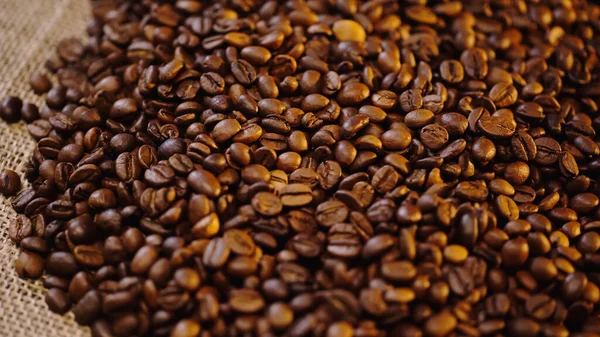 High angle view of roasted and fresh coffee beans on canvas — Stock Photo