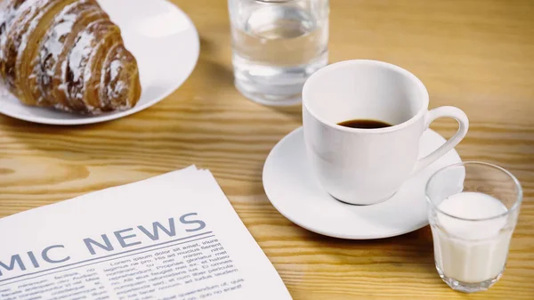 Verre de lait près de tasse de café, journal et croissant — Photo de stock