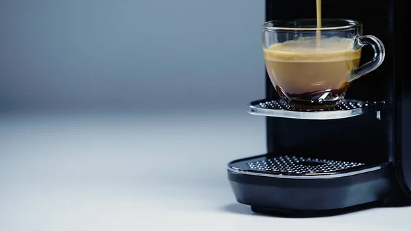 Automatic coffee maker pouring hot drink into cup on gray — Foto stock