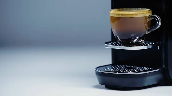 Kaffeemaschine mit Glas Kaffee auf grau — Stockfoto
