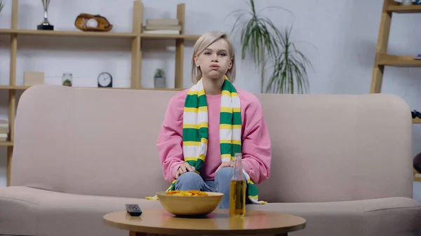 Frustrated sport fan woman puffing cheeks while watching match on sofa at home — Fotografia de Stock