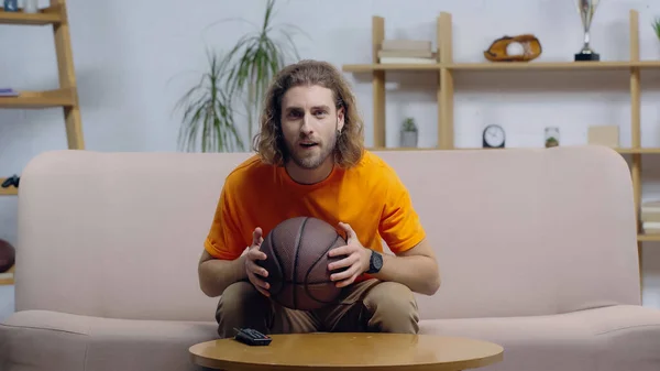 Focused sport fan watching basketball match on tv at home — Stock Photo