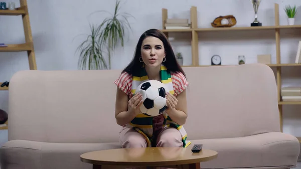Excité fan de sport femme avec ballon de football regarder le championnat de football sur la télévision à la maison — Photo de stock