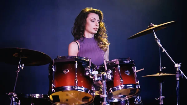 Pretty drummer playing on drums during performance on stage — Foto stock