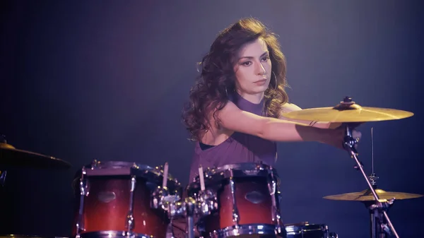 Curly drummer playing on drums on stage — Stock Photo