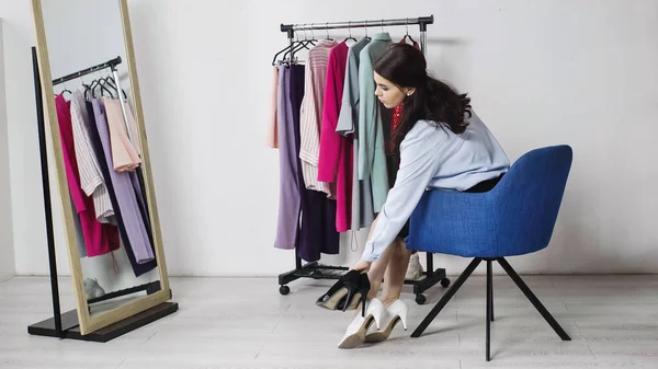 Mujer comparar zapatos cerca espejo en casa - foto de stock