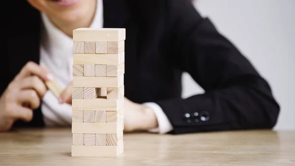 Обрізаний вид бізнес-леді, що грає в блоки дерев'яна гра ізольована на сірому — стокове фото