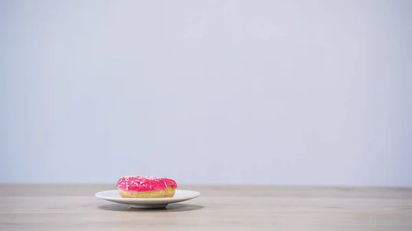 Sweet glazed doughnut on plate isolated on grey — Foto stock