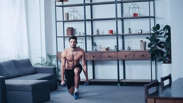 Shirtless sportsman training with dumbbells at home — Stock Photo