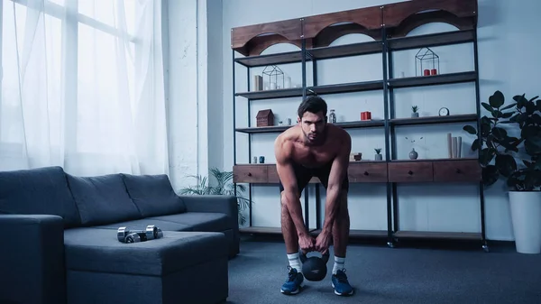 Entraînement sportif musclé avec kettlebell à la maison — Photo de stock