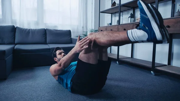 Young and sportive man working out on floor — Stock Photo