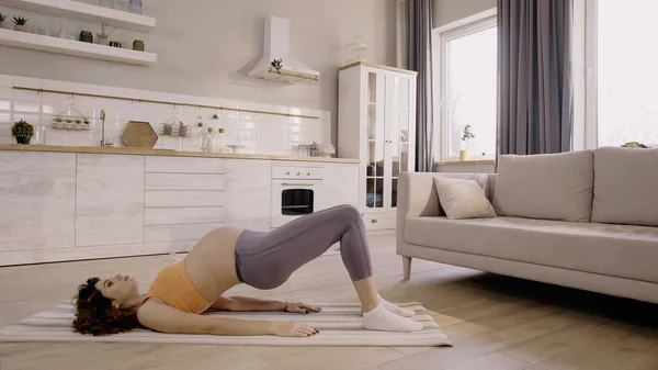 Pregnant woman training on fitness mat at home — Fotografia de Stock