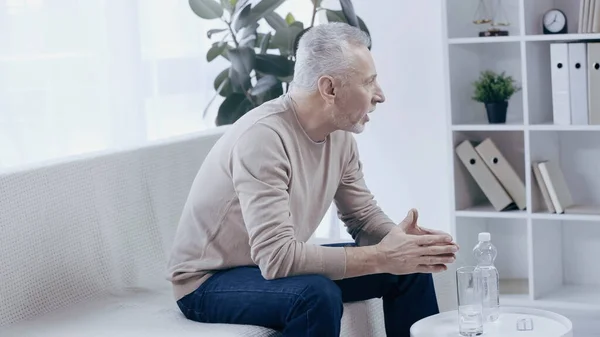 Besorgter älterer Mann spricht während Psychotherapie im Sprechzimmer — Stockfoto