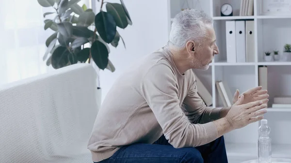 Тривожний чоловік середнього віку розмовляє під час психотерапії — стокове фото