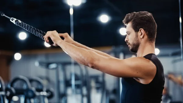 Side view of bearded sportsman exercising in gym — Stock Photo