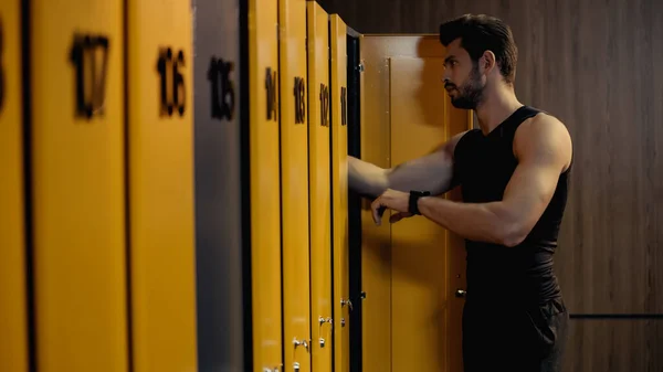 Bearded sportsman with smart watch standing in locker room — Foto stock