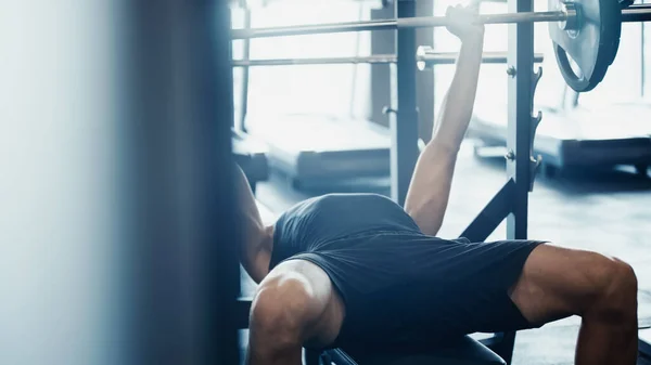 Deportista fuerte haciendo ejercicio con barra en el gimnasio - foto de stock