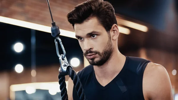 Bearded young sportsman exercising in gym — Stock Photo