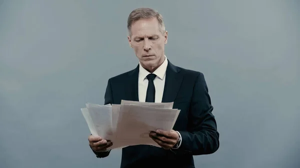 Mature manager holding documents isolated on grey — Stock Photo