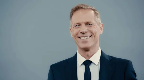 Smiling businessman in formal wear looking at camera isolated on grey — стоковое фото