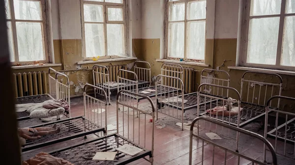 Intérieur de la maternelle abandonnée avec lits métalliques dans la zone d'exclusion de Tchernobyl — Photo de stock