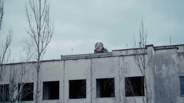 Old building and trees in chernobyl abandoned city under grey sky — Stock Photo