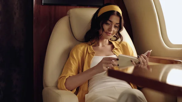 Young smiling woman reading book in private jet — Stock Photo