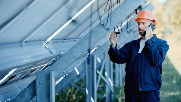 Ingenieur checkt Draht und spricht auf Smartphone — Stockfoto