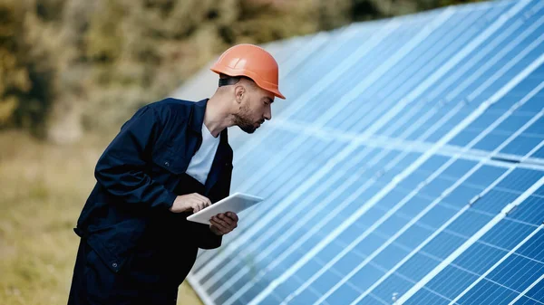 Ingénieur en utilisant gadget et en regardant le panneau solaire — Photo de stock