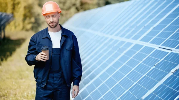 Engineer holding paper cup and looking at camera - foto de stock