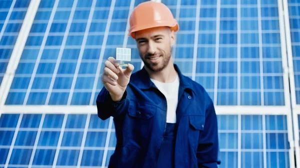 Lächelnder Ingenieur zeigt kleines Modell einer Solarzelle — Stockfoto