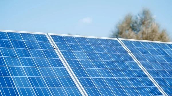 Construção azul de painéis de bateria solar contra o céu — Fotografia de Stock