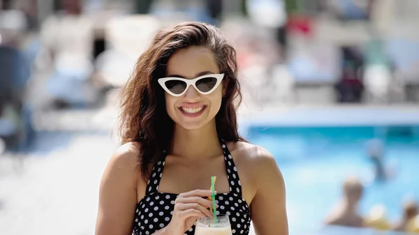 Happy young woman in sunglasses holding cocktail — Stock Photo