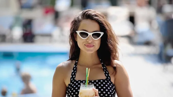 Felice giovane donna in occhiali da sole e costume da bagno con cocktail in vetro — Foto stock