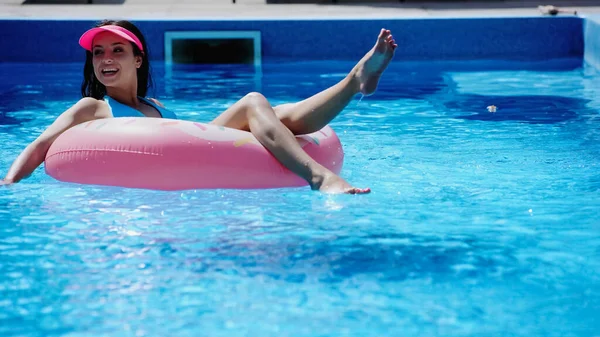 A piedi nudi e felice donna nuotare su anello gonfiabile in piscina — Foto stock