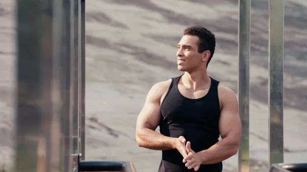 Athletic mixed race sportsman looking away at outdoor gym on blurred foreground — Stock Photo