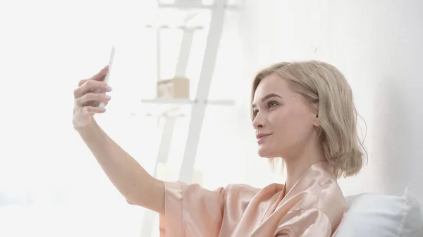 Allegra donna bionda scattare selfie su smartphone — Foto stock